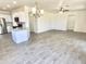 Spacious living room open to kitchen with breakfast bar, ceramic tile floors, and modern lighting at 7116 W Sophie Ln, Laveen, AZ 85339