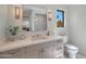 Bright bathroom with a marble countertop vanity, modern lighting, and decorative mirror at 733 W El Camino Dr, Phoenix, AZ 85021