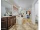 Serene bathroom featuring dual vanities, soaking tub, and tiled floors for a luxurious spa-like experience at 7419 S 25Th Dr, Phoenix, AZ 85041