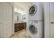 Bathroom featuring a stackable washer and dryer and vanity with double sinks at 7419 S 25Th Dr, Phoenix, AZ 85041