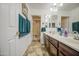 Bathroom with double sinks, brown cabinets, and a shower behind a glass door at 7419 S 25Th Dr, Phoenix, AZ 85041