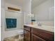 Bathroom featuring a shower-tub combo and a single sink vanity with a brown cabinet at 7419 S 25Th Dr, Phoenix, AZ 85041