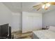 Bedroom featuring a bed, TV, ceiling fan, wood-like flooring, and a closet at 7419 S 25Th Dr, Phoenix, AZ 85041