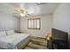 Bedroom featuring a bed, TV, ceiling fan, wood-like flooring, and natural light at 7419 S 25Th Dr, Phoenix, AZ 85041