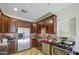 Kitchen showcasing stainless steel appliances, dark cabinets, and tile flooring at 7419 S 25Th Dr, Phoenix, AZ 85041
