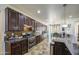 Gourmet kitchen with dark cabinets, granite countertops, stainless steel appliances, and tile floors at 7419 S 25Th Dr, Phoenix, AZ 85041