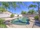 Freeform swimming pool with rock accents and lush landscaping creates a resort-like backyard oasis at 7419 S 25Th Dr, Phoenix, AZ 85041