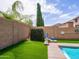 Beautiful backyard with synthetic grass, lush plants, and a sparkling pool for outdoor enjoyment at 761 W Desert Hollow Dr, San Tan Valley, AZ 85143