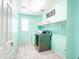 Bright laundry room with modern appliances, shelving, and stylish tile flooring at 761 W Desert Hollow Dr, San Tan Valley, AZ 85143