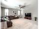 Spacious living room with a large leather sectional, ceiling fan, and neutral decor at 761 W Desert Hollow Dr, San Tan Valley, AZ 85143