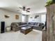 Spacious living room with a large sectional sofa, ceiling fan, and vintage-themed decorations at 761 W Desert Hollow Dr, San Tan Valley, AZ 85143