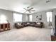 Spacious living room featuring a large sectional sofa, neutral carpeting, and a ceiling fan for comfort at 761 W Desert Hollow Dr, San Tan Valley, AZ 85143