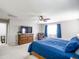 Bright main bedroom with a ceiling fan, dresser with tv, and king bed covered with blue comforter at 761 W Desert Hollow Dr, San Tan Valley, AZ 85143