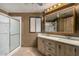 Bathroom featuring a double vanity, shower, and dark brown wood paneled walls at 8103 E Southern Ave # 119, Mesa, AZ 85209