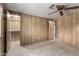 Open Bedroom featuring paneled walls, multiple doors, and a ceiling fan at 8103 E Southern Ave # 119, Mesa, AZ 85209