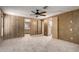 Bright bedroom featuring an adjoining bathroom, wood paneled walls, and a walk-in closet at 8103 E Southern Ave # 119, Mesa, AZ 85209