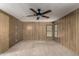Cozy bedroom featuring wood paneling, neutral carpet, and a ceiling fan at 8103 E Southern Ave # 119, Mesa, AZ 85209