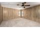 Spacious bedroom with wood paneled walls, a ceiling fan, and neutral carpet at 8103 E Southern Ave # 119, Mesa, AZ 85209