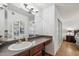 The bathroom features a dark wood vanity, artwork, and a view into the bedroom at 8787 E Mountain View Rd # 1100, Scottsdale, AZ 85258