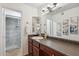 This is a vanity with a white sink, dark wood cabinets, and artwork on the wall at 8787 E Mountain View Rd # 1100, Scottsdale, AZ 85258