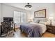 This is a bedroom with a ceiling fan, a desk with a computer, and tiled floors at 8787 E Mountain View Rd # 1100, Scottsdale, AZ 85258