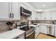 Modern kitchen with stainless appliances, white cabinets, and stone backsplash at 8787 E Mountain View Rd # 1100, Scottsdale, AZ 85258