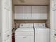 Functional laundry room with washer, dryer, and built-in storage cabinets at 8787 E Mountain View Rd # 1100, Scottsdale, AZ 85258