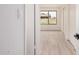 Hallway featuring white doors, white walls, and wood look floors and a view to the back yard at 9414 N 50Th Dr, Glendale, AZ 85302