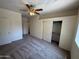 This carpeted bedroom includes a ceiling fan, closet, and multiple doors to other parts of the home at 1015 S Val Vista Dr # 52, Mesa, AZ 85204