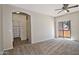 Spacious carpeted main bedroom with a ceiling fan, closet, and sliding glass door at 1015 S Val Vista Dr # 52, Mesa, AZ 85204