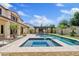 Beautiful backyard with a sparkling pool, spa, and outdoor kitchen, creating an oasis for relaxation and entertainment at 10331 E Starion Ave, Mesa, AZ 85212