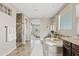 A tranquil bathroom offers a soaking tub, natural light, and a glimpse into the Primary bedroom at 10331 E Starion Ave, Mesa, AZ 85212
