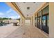 Spacious covered patio with travertine flooring, offering an elegant outdoor space for dining and entertaining near the pool at 10331 E Starion Ave, Mesa, AZ 85212