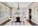 Elegant dining room with a large table, white chairs, and modern chandelier at 10331 E Starion Ave, Mesa, AZ 85212