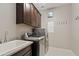 Functional laundry room is equipped with washer, dryer, sink, and ample cabinet storage at 10331 E Starion Ave, Mesa, AZ 85212