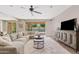 Bright living room featuring a large sectional, TV, entertainment center, and seamless indoor-outdoor flow to the pool area at 10331 E Starion Ave, Mesa, AZ 85212