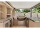 Well-equipped outdoor kitchen featuring a built-in grill, refrigerator, and ample counter space for outdoor cooking and entertaining at 10331 E Starion Ave, Mesa, AZ 85212