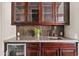 Elegant wet bar with rich wood cabinetry, granite countertop, stylish backsplash, and beverage cooler at 10331 E Starion Ave, Mesa, AZ 85212