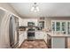 Spacious kitchen with stainless steel appliances, white cabinets, tile flooring, and breakfast bar at 11361 E Escondido Ave, Mesa, AZ 85208