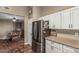 Kitchen with stainless steel appliances, white cabinets, and tile floors overlooking dining area at 11361 E Escondido Ave, Mesa, AZ 85208