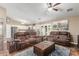 Open-concept living room featuring leather sofas, ceiling fan, and access to the kitchen at 11361 E Escondido Ave, Mesa, AZ 85208