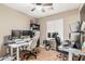Home office with multiple desks, ceiling fan, and natural light, ideal for productivity at 11361 E Escondido Ave, Mesa, AZ 85208