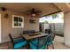 Cozy covered patio featuring a ceiling fan, stone flooring and a patio table with six chairs at 11361 E Escondido Ave, Mesa, AZ 85208