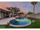 Backyard pool featuring a stone waterfall feature, lush landscaping, and a covered outdoor kitchen area at 11361 E Escondido Ave, Mesa, AZ 85208