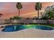 A backyard swimming pool is beautifully lit and features a rock waterfall with two palm trees in the background at 11361 E Escondido Ave, Mesa, AZ 85208