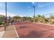 Outdoor pickleball court with a red surface, surrounded by desert landscaping and a chain-link fence, under a clear blue sky at 11658 E Chevelon Trl, Gold Canyon, AZ 85118
