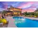 Backyard pool and patio area with mountain views at dusk at 12015 S Tuzigoot Dr, Phoenix, AZ 85044