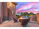 Backyard firepit lounge area near spiral staircase, with pool in background at sunset at 12015 S Tuzigoot Dr, Phoenix, AZ 85044
