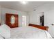 Spacious bedroom with a wooden bed, white bedding, and an open closet, complemented by light-colored wood floors at 12015 S Tuzigoot Dr, Phoenix, AZ 85044