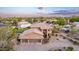 Exterior home view with a spacious three-car garage, desert landscaping, and tile roof at 12015 S Tuzigoot Dr, Phoenix, AZ 85044